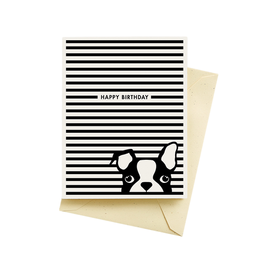 A card with horizontal black stripes on a white background and text that reads, "happy birthday". There is a  dog in black and white popping up in front of the black stripes with one ear flopped over.